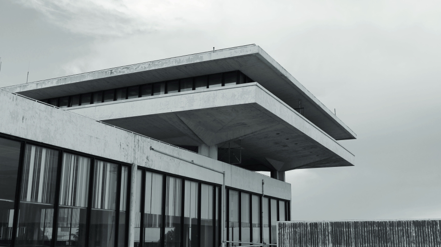 Ασπρόμαυρη φωτογραφία κτιρίου με φωτεινή επιγραφή: «Olympic Airways Κεντρικός Αερολιμήν Αθηνών Athens Airport».