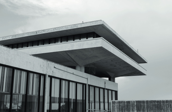 Ασπρόμαυρη φωτογραφία κτιρίου με φωτεινή επιγραφή: «Olympic Airways Κεντρικός Αερολιμήν Αθηνών Athens Airport».